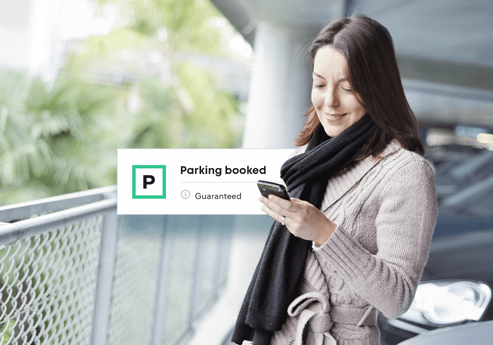 Woman using the YourParkingSpace app in a parking lot
