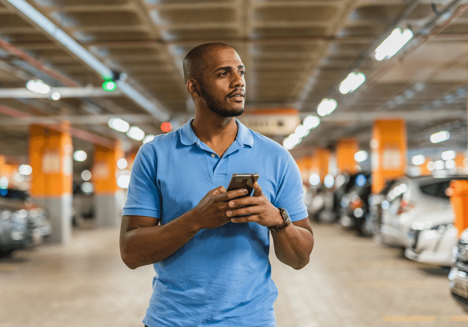 Man looking at his phone in a parking lot