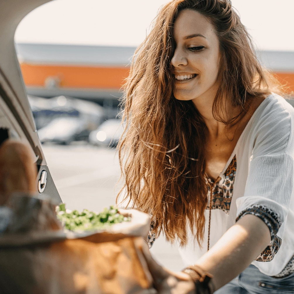 Woman putting groceries in her car