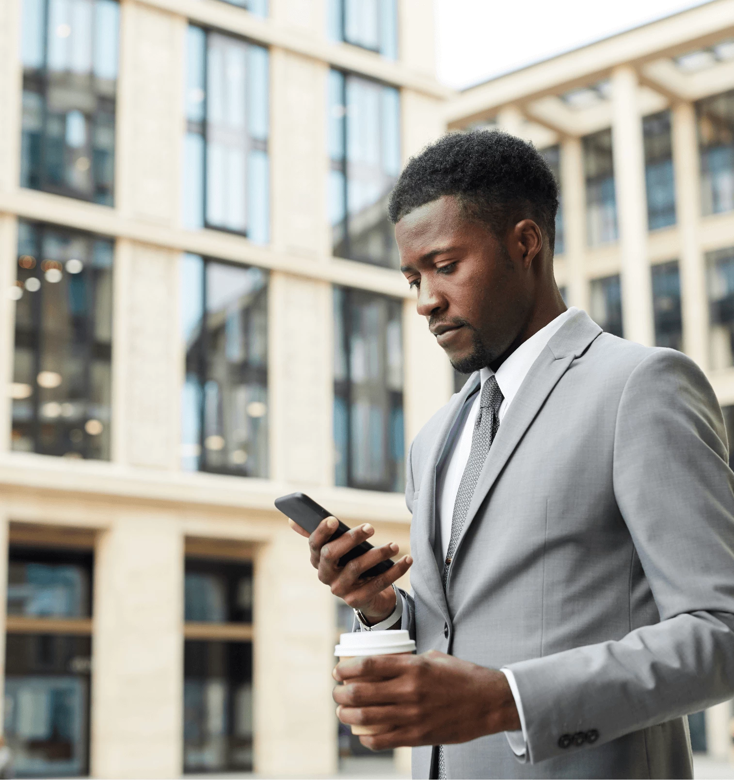 Man using the YourParkingSpace App and holding a coffee